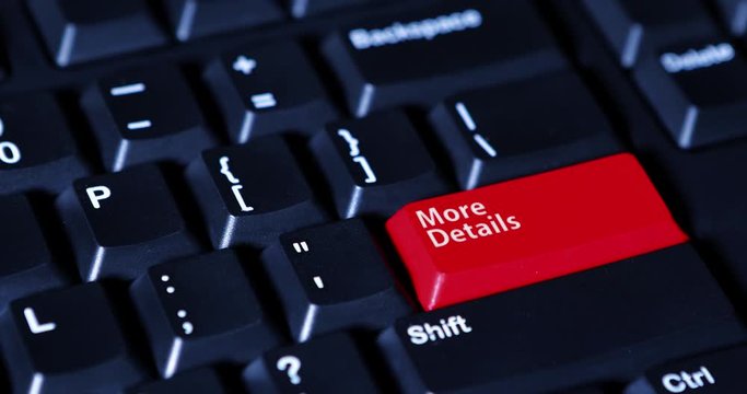 Close up of human hand pushing a red button with text of More Details on the computer keyboard