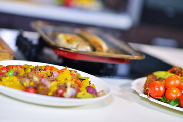 Grilled sausage with grilled vegetables on kitchen table