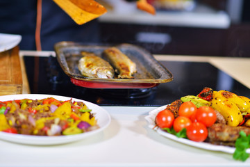 Grilled sausage with grilled vegetables on kitchen table