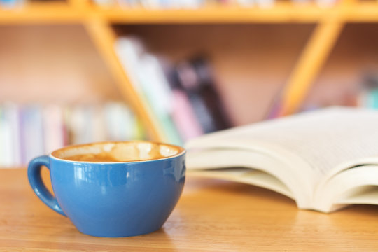 Blue Coffee Cup With Book On Table.