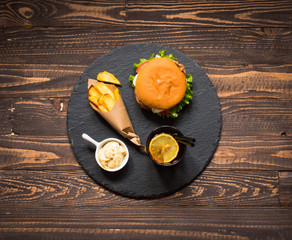 Top view of delicious hamburger, with vegetables,  on a wooden background.