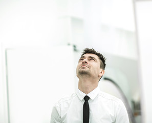 successful businessman in white shirt and tie looking up.