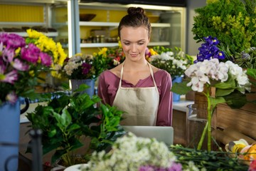 Florist using laptop in flower shop