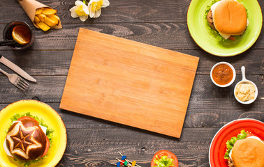 Top view of delicious hamburger, with vegetables,  on a wooden background.