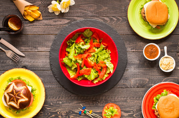 Top view of delicious hamburger, with vegetables,  on a wooden background.