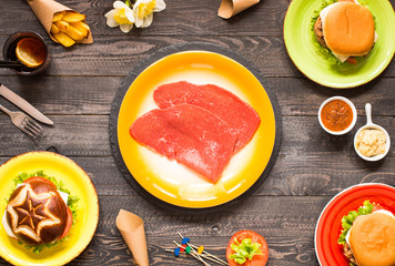 Top view of delicious hamburger, with vegetables,  on a wooden background.