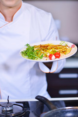 Man's hand holding an egg. White chicken egg. Chef starts preparing omelet.