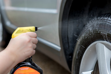 Spraying Cleaner on Tire - 141439034