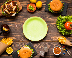 Top view of delicious hamburger, with vegetables,  on a wooden background.