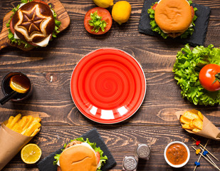 Top view of delicious hamburger, with vegetables,  on a wooden background.
