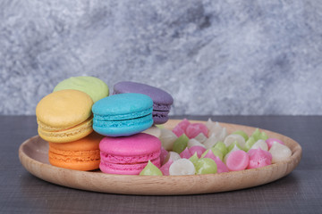 sweet colorful cake macaron and Aalaw or Alua candy in plate on wood table