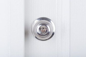 Aluminum door knob on white door