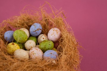 Colorful chocolate Easter eggs in the nest