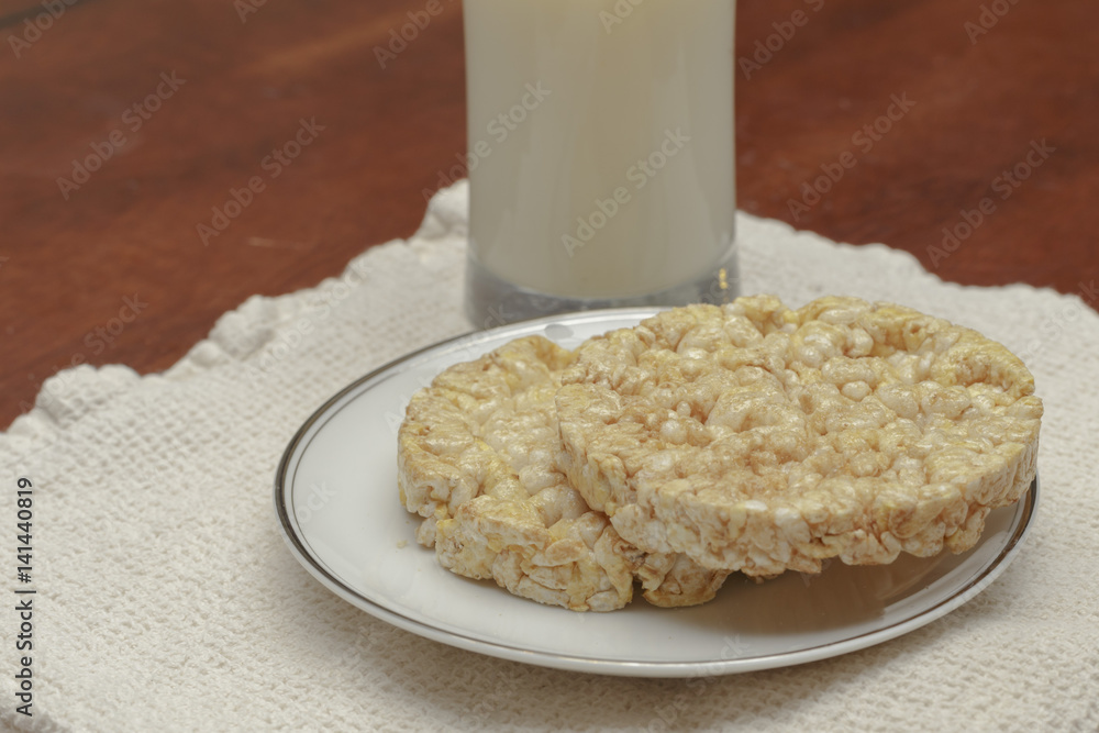 Wall mural rice cakes on a plate with a glass of milk