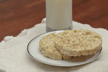 rice cakes on a plate with a glass of milk