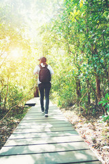 woman trekking in forest and sun light