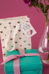 Close-up of gift box, paper bag and flowers vase
