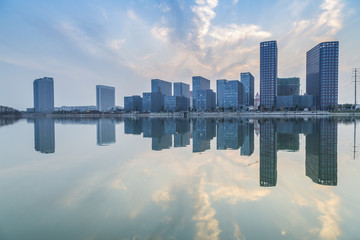 lake with modern business office building at sunset