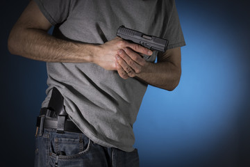 Man drawing a concealed carry pistol from a holster