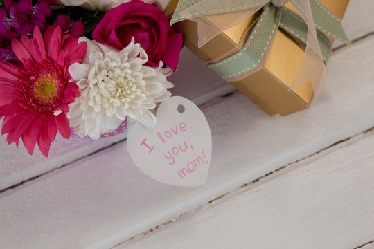 Gift box and bunch of fresh flowers with I love you mom card