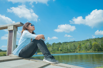 Happy woman with sit down and relax and lagoon at sunset