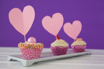 Close-up of three cupcakes with heart cards
