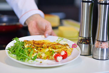 Man's hand holding an egg. White chicken egg. Chef starts preparing omelet.
