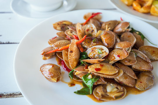 Spicy clams with sauce and chilli on white dish