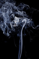 Abstract art. Color white blue smoke from the aromatic sticks on a black background. Background for Halloween. Texture fog. Design element. The concept of aromatherapy.