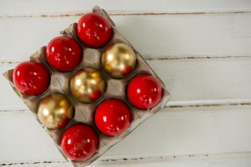 Red and golden Easter eggs in the carton