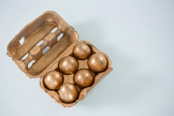 Close-up of golden Easter eggs in the carton