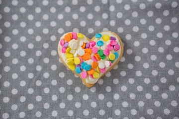 Decorated heart shape cookie against polka dot background