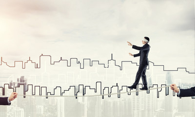 Business concept of risk support and assistance with man balancing on rope