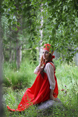 Slav in traditional dress is sitting in nature