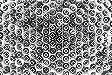 Pattern of white tubes, repeated square elements, black hexagons and surfaces