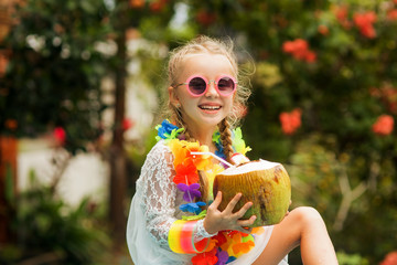  Cute smiling girl in sunglasses, flower beads with a coconut drink. Photo with HDR processing.