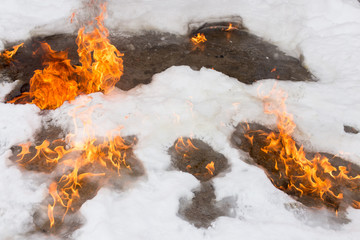 fiery flame on the white snow in winter