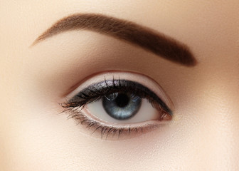 Close-up macro of beautiful female eye with perfect shape eyebrows. Clean skin, fashion naturel...