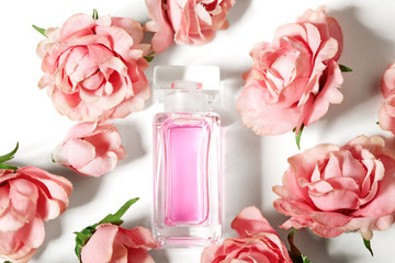 Perfume bottle in pink flower roses. Spring background with luxury aroma parfume. Beauty cosmetic...