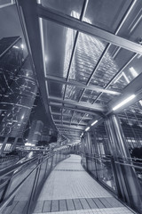 pedestrian walkway and skyscraper in Hong Kong city at night