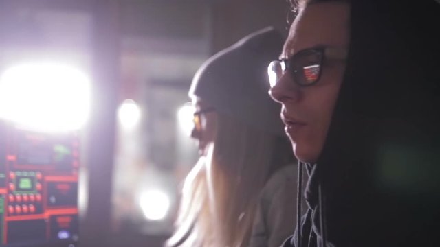 Two hackers at the computers. Computers screens with code on a background. HD.