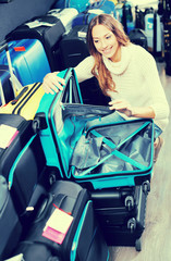 Smiling female looking at roll-aboard bags