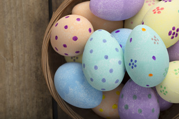 Close Up of Painted Eggs in Wicker Bowl Copy Space