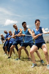 People playing tug of war during obstacle training course