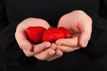 Woman holding a handful of delicious strawberries