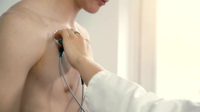 Female doctor monitors the progress of the a young man ECG