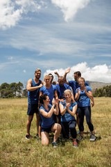 Group of fit people cheering together in boot camp