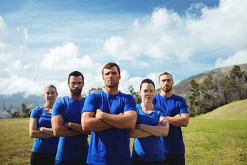 Group of fit people together with arms crossed in a boot camp