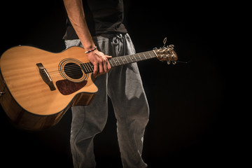 young man with acoustic guitar on black background