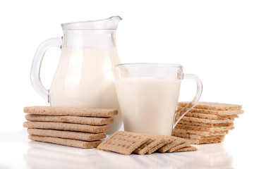 jug and glass of milk with grain crispbreads isolated on white background